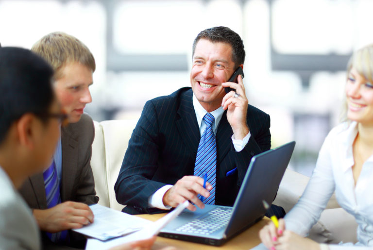 Business man speaking on the phone while in a meeting